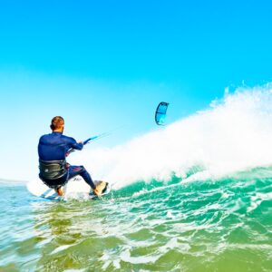 Guy kite surfing a wave in Essaouira beach in a sunny day.