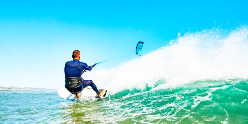 Guy kite surfing a wave in Essaouira beach in a sunny day.